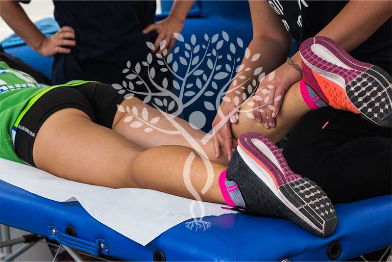 massaging an athlete's calf in a sports massage therapy session